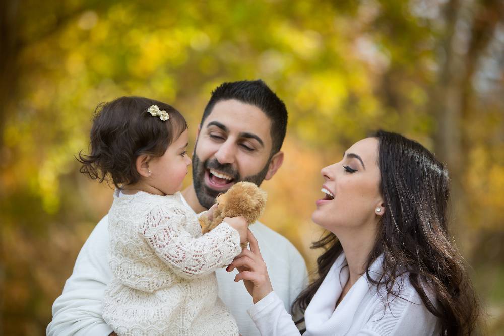 Beautiful couple and child daughter together in a Cherry Blossom Forest